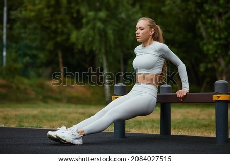 Similar – Image, Stock Photo Athletic woman doing triceps push-ups with a barbell plate