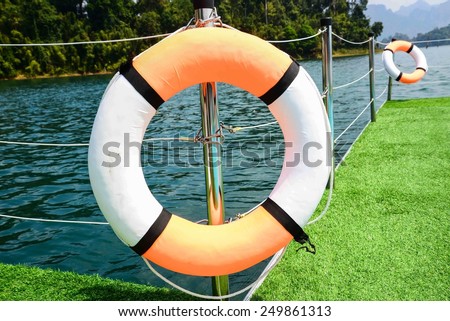 Plastic orange saving belt by the railing fence of the ferry