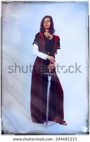 A beautiful young woman posing in historical dress with a sword in her hands