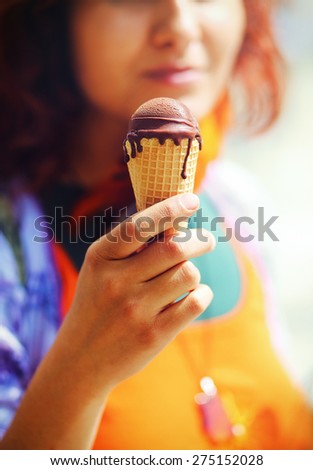 Girl offering a chocolate ice cream on an early summer day, Ice cream in woman\'s hand