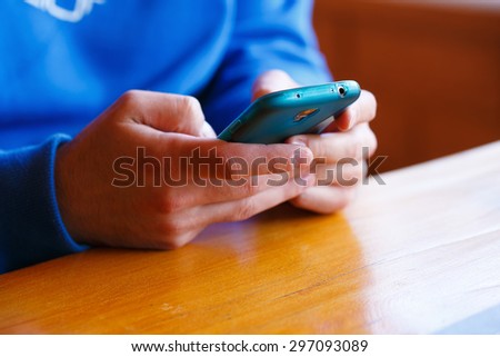 man with  restaurant and playing on a smartphone.