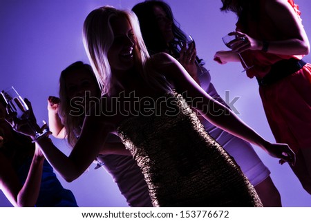 A group of young beautiful people dancing at a disco.