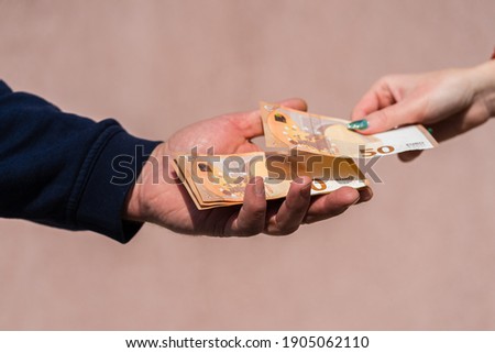 Hand giving money like bribe or tips or salary isolated, hard worked hand taking euro banknotes. Currency transfer and reward for hard work. Foto d'archivio © 
