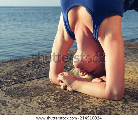 Girl practicing yoga standing on hands. Outdoor. Close-up portrait