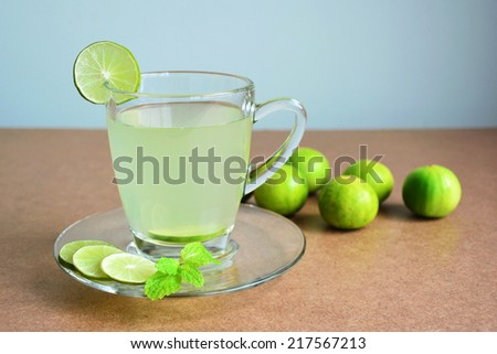 Lemon juice, Lime juice and limes on wooden table.