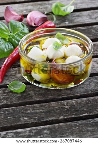 Mozzarella marinated with garlic, spices and basil in olive oil.Selective focus.