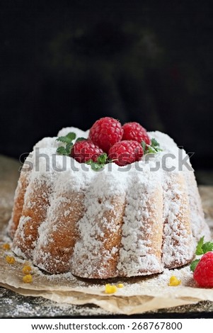 Vanilla cake with fresh raspberry on a rustic dark background.Selective focus.