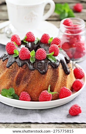 Vanilla-chocolate bundt cake with fresh raspberries on a wooden background. Selective focus