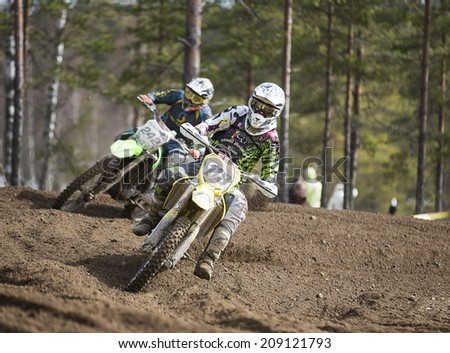 LAITILA, FINLAND - APRIL 20: A motocross drivesr curves fast in a dirt track . Image taken in West Cross Weekend championships in Laitila, Finland in April 20th 2014.