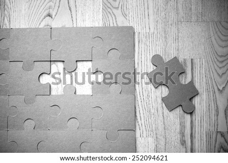 A puzzle missing one piece. Image in black and white.