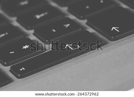 A macro shot from keyboard. Enter key in focus. Image has vintage effect in black and white.