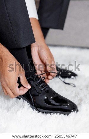 Foto Bild Seriöser Mann beim Schnüren von Stiefeletten