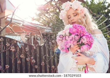 Beautiful woman with the bouquet of peonies