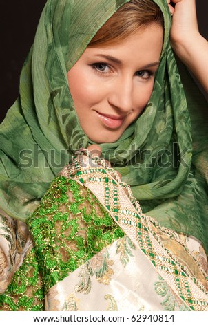 Young arab woman with veil close-up portrait on dark background