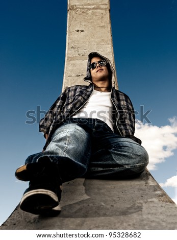 Young man urban fashion portrait over sky background