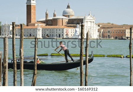 VENICE, ITALY - JUNE 6: a gondolier on the Grand Canal on June 6, 2013 in Venice, Italy. Venice is one of the world\'s most popular tourist destinations with 21 million visitors per annum.