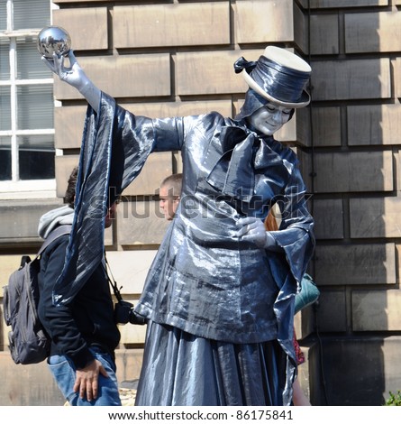 EDINBURGH - JULY 30: A human statue performs at the annual Fringe Festival on July 30, 2011 in Edinburgh, Scotland. 1.9 million tickets are sold for the festival each year.