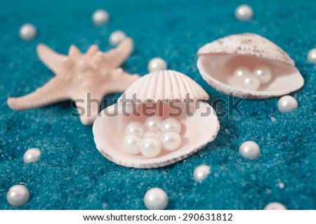 shells and pearls isolated on blue background made of little blue rocks