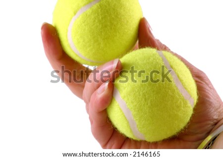 two tennis balls being held by a tennis player