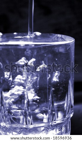 glass being filled with water and overflowing with bubbles