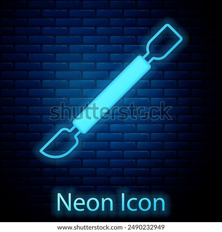 Glowing neon Cuticle pusher icon isolated on brick wall background. Tool for manicure.  Vector