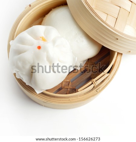 Chinese steamed buns in bamboo basket isolated on white background