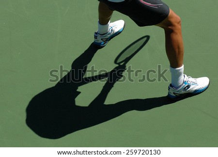 VANCOUVER, CANADA - AUGUST 7, 2014: An athlete casts a shadow during tennis match in Stanley Park in Vancouver, Canada, on August 7, 2014.