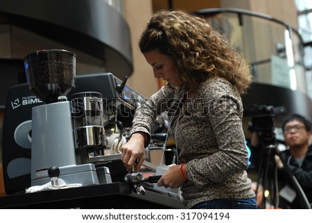 VANCOUVER, CANADA - OCTOBER 19, 2013: A barista prepares a cup of latte during public event to promote coffee beverages in Vancouver, Canada, October 19, 2013.