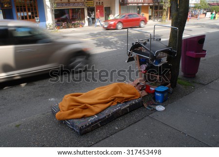 VANCOUVER, CANADA - JUNE 1, 2012: Homeless people, like pictured ones, can be seen almost on every corner of every street in the heart of downtown in Vancouver, Canada, June 1, 2012.
