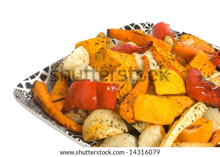 Oven roasted vegetables on china platter isolated over white background