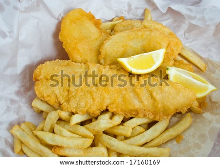 Deep fried fish and chips with lemon with paper wrapping