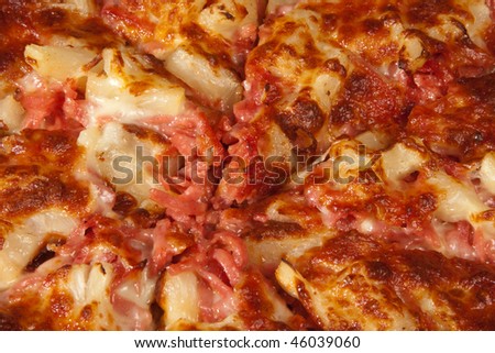 Freshly baked ham and pineapple pizza cut into slices