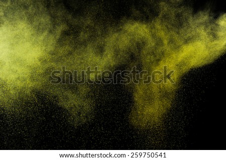 Abstract yellow and gold  paint Holi. Abstract yellow and gold powder explosion on black background.