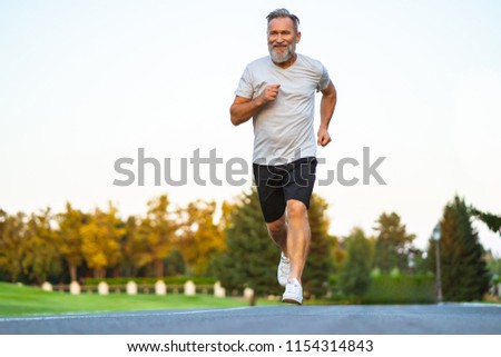 Foto Bild Sportler laufen auf Asphaltstrasse in den Bergen