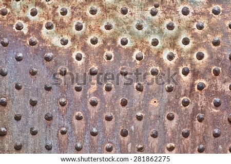 Rusty metal texture. Studded iron plate. Rivets on old, rusty, metal door. Weathered, aged, grunge texture.
