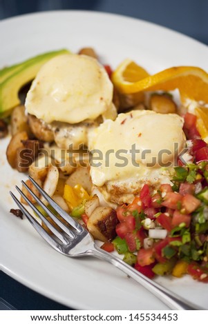 poached eggs over Dungeness crab cakes with chipotle Hollandaise sauce on a bed of roasted potatoes