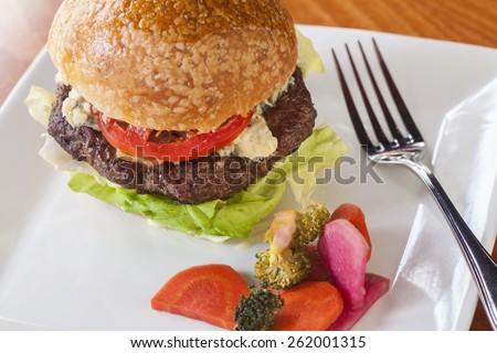 Burger with caramelized onions, blue cheese and aioli served with pickled vegetables