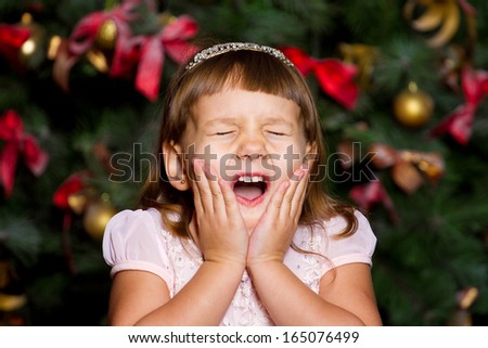 Girl in a Christmas tree. Surprise. Emotions. delight