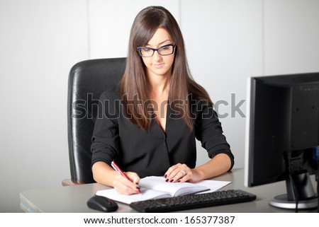 Office lady writing down a week plan in her organizer