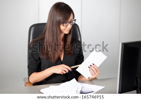 Portrait of a beautiful executive woman secretary at work while open a letter