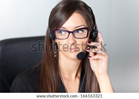 Happy support phone operator in headset at workplace