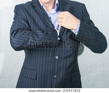 young man in a suit pulls something from his jacket pocket