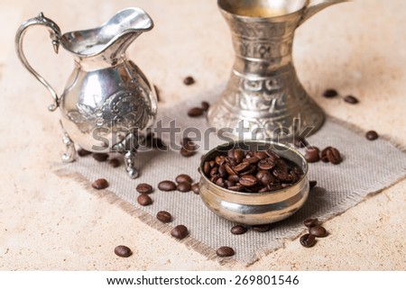 coffee beans in bowl milk jug and coffee pot on stone background