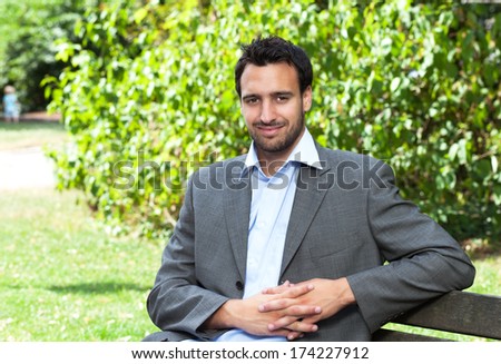 Attractive latin businessman relaxing in a park