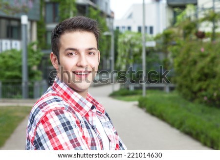 Smart student with checked shirt laughing at camera