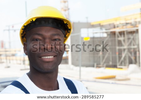 Happy african american construction worker at building site