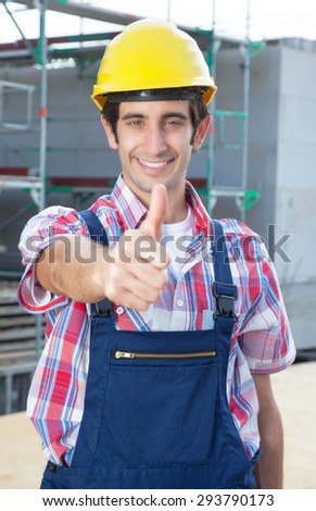 Hispanic construction worker at building site with showing thumb up