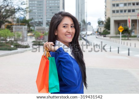 Beautiful latin woman with shopping bags in the city