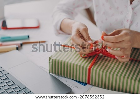 Similar – Image, Stock Photo Woman ties a ribbon bow on a wrapped present