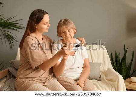 Similar – Image, Stock Photo Adult daughter teaching her elderly mother to use laptop